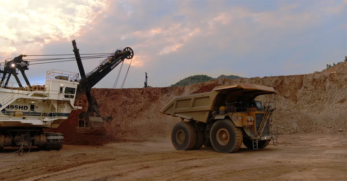 Corporate video production — Bucyrus electric shovel loading a haul truck at an open-pit mine at dusk