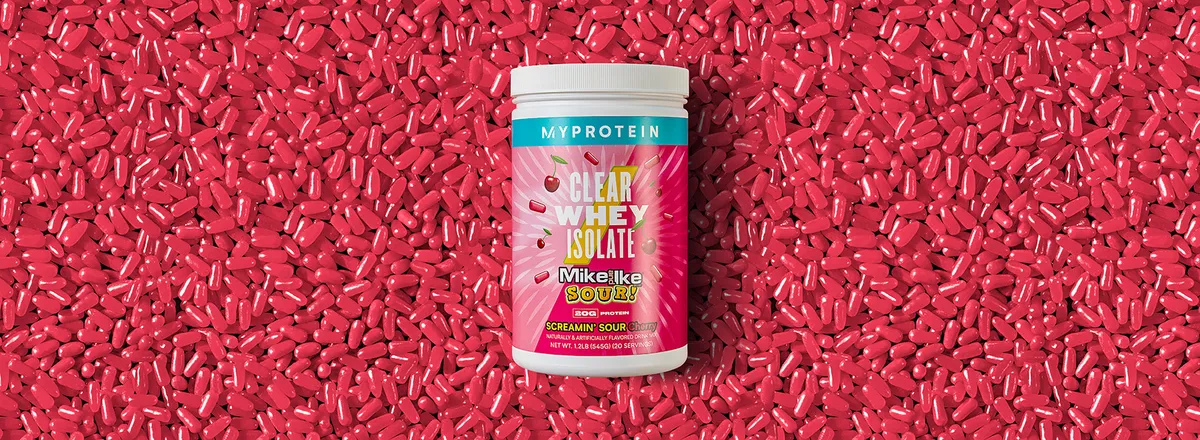 Myprotein product photoshoot — Clear Whey Isolate Mike and Ike Sour Cherry tub on red candy