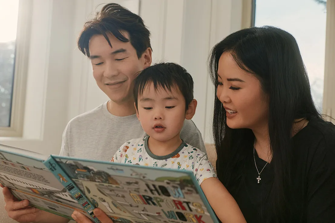 Documentary production still — family reading a children's book together at home